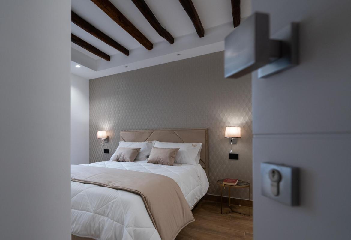camera con travi a vista e letto matrimoniale nel centro storico di Sciacca