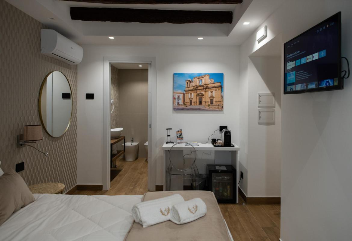 camera con tv e travi a vista nel centro storico di Sciacca