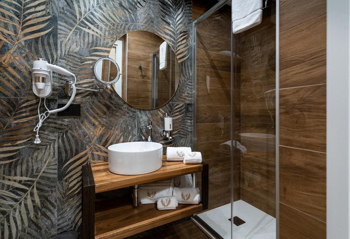 spazio bagno con finiture materiche e arredi contemporanei a Sciacca