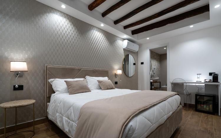 letto matrimoniale con biancheria ordinata e cuscini decorativi