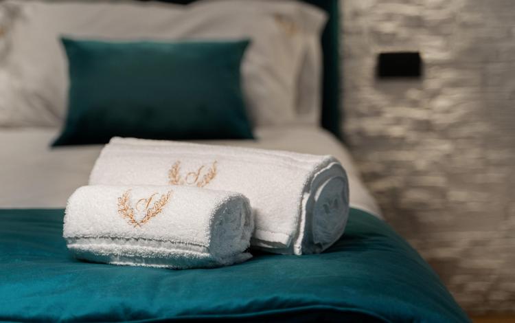 letto matrimoniale con set asciugamani e biancheria curata