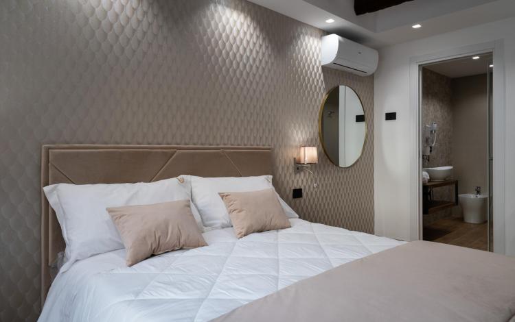 camera luminosa con letto matrimoniale e arredi curati